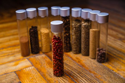 Assorted ground spices in bottles on wooden background