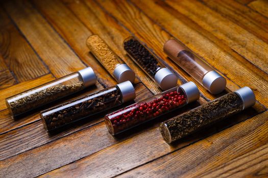 Assorted ground spices in bottles on wooden background