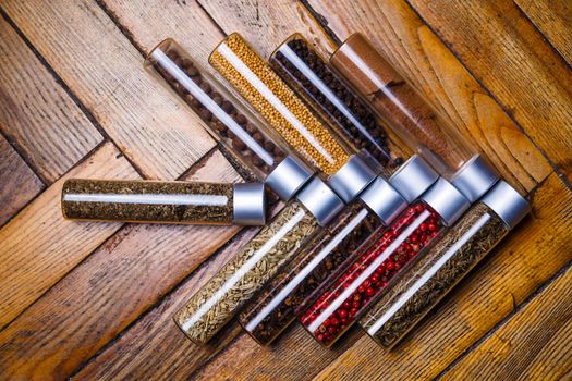 Assorted ground spices in bottles on wooden background