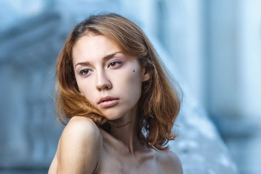 Fashion portrait shoot of a beautiful teen girl during city fashion shoot with classical building at background