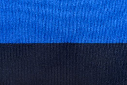Knit woolen texture. Fabric blue background
