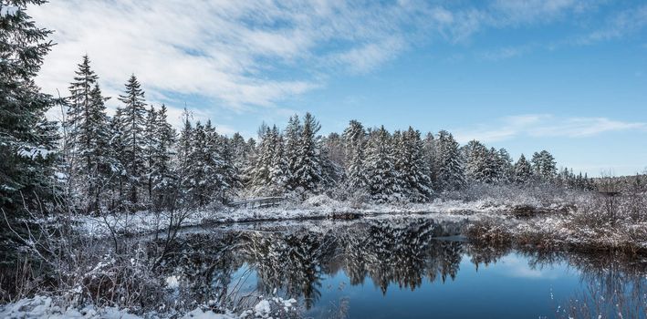 Chalk River foot bridge and nature trail walking path on a blue sky morning and fresh fallen snow.