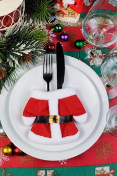 Fragment of the Christmas table serving coat of Santa Claus with cutlery