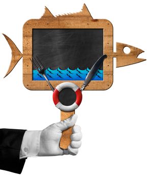 Hand of chef holding a blackboard in the shape of fish with cutlery, blue waves and lifebuoy. Isolated on white background