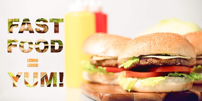 Hamburgers with cheese, potato chips and ingredients on a white background with typography