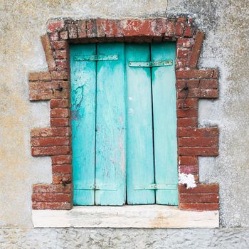 Window of a farmhouse with wooden balconies and red brick frame.