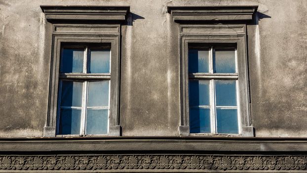 Dilapidated windows on the facade of an old tenement in Katowice, Silesia region, Poland.