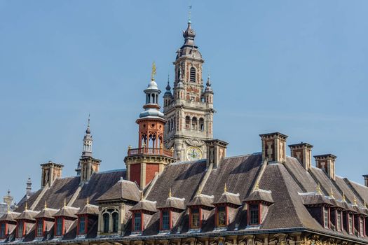 The belfry of the Chamber of Commerce preceded by the roof of the Vieille Bourse (Old Stock Exchange) from the General de Gaulle, Square in Lille, France.