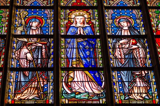Magnificent stained glass windows in the Cathedral of Notre Dame de Sablon in Brussels, created in XVI century. Virgin Mary in the centre, surrounded by the Saints.