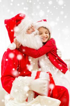 holidays, christmas, happiness and people concept - smiling girl with gift box embracing santa claus at home