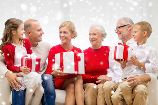 family, holidays, generation, christmas and people concept - smiling family with gift boxes sitting on couch at home