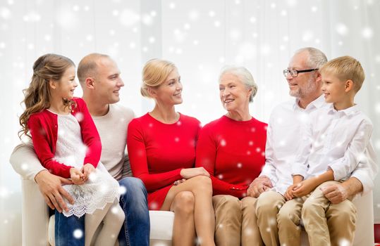 family, holidays, generation, christmas and people concept - smiling family sitting on couch at home