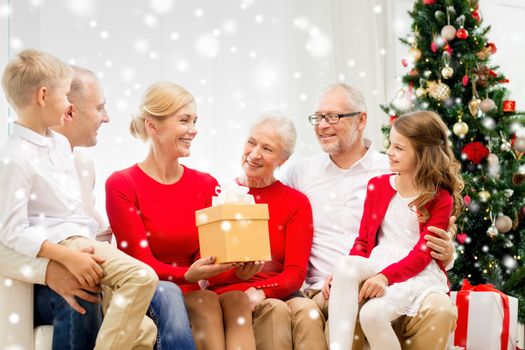 family, holidays, generation, christmas and people concept - smiling family with gift boxes sitting on couch at home