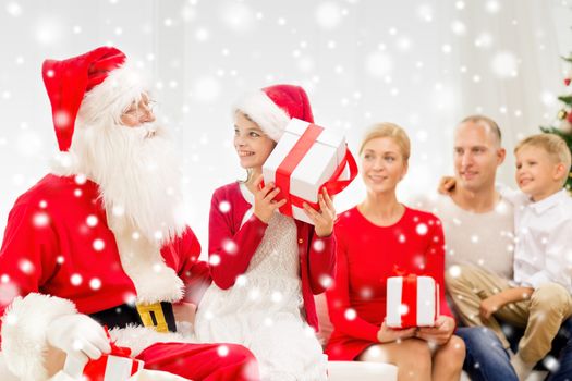 family, holidays, generation, christmas and people concept - smiling family with santa claus and gift boxes at home