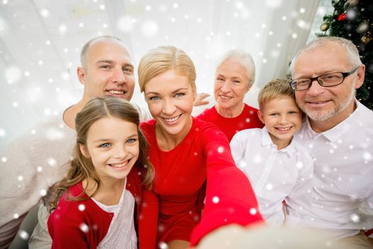 family, holidays, generation, christmas and people concept - smiling family with camera or smartphone taking selfie at home