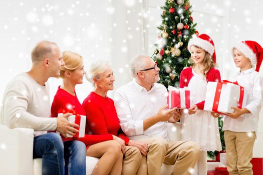 family, holidays, generation, christmas and people concept - smiling family with gift boxes sitting on couch at home