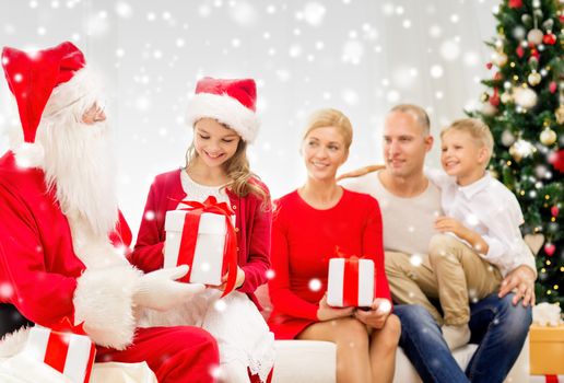 family, holidays, generation, christmas and people concept - smiling family with santa claus and gift boxes at home