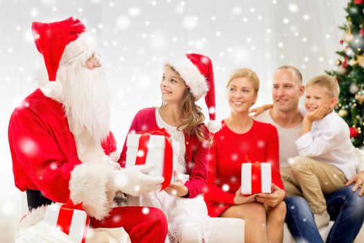 family, holidays, generation, christmas and people concept - smiling family with santa claus and gift boxes at home