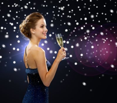 party, drinks, holidays, christmas and people concept - smiling woman in evening dress with glass of sparkling wine over night lights and snow background