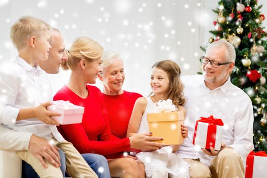 family, holidays, generation, christmas and people concept - smiling family with gift boxes sitting on couch at home