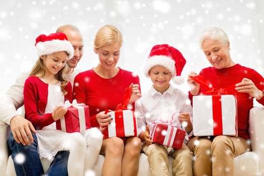 family, holidays, generation, christmas and people concept - smiling family opening gift boxes at home