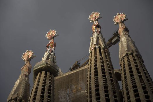 Barcelona, Spain - September 19, 2015: Ornamentation at top of Sagrada Familia Passion side towers. Gaudi's profound catholicism inspired his designs of Sagrada Familia.