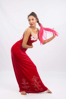 Mulatto girl dancer performs a dance elements, isolated on a light background