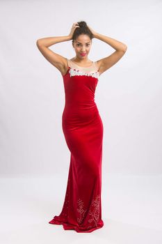 Mulatto girl dancer performs a dance elements, isolated on a light background