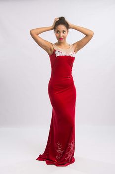 Mulatto girl dancer performs a dance elements, isolated on a light background