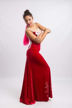 Mulatto girl dancer performs a dance elements, isolated on a light background