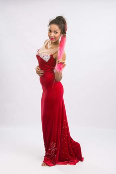 Mulatto girl dancer performs a dance elements, isolated on a light background
