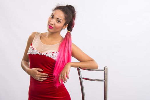 Mulatto girl dancer performs a dance elements, isolated on a light background