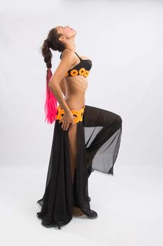 Young girl mulatto dancing in a long black candid open dress, is isolated on a light background