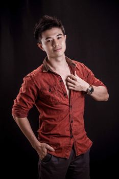 Portrait of Asian young man on black background - casual red shirt