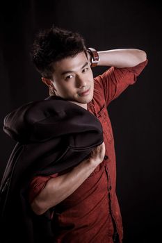 Portrait of Asian young man on black background - casual red shirt