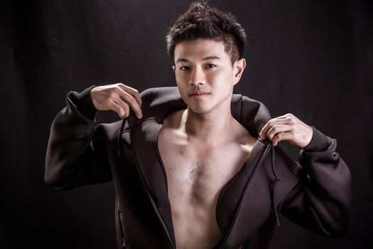 Portrait of Asian young man on black background - Fitness healthy guy
