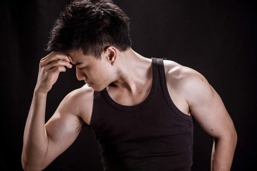 Portrait of Asian young man on black background - Show muscle and strengh