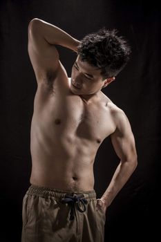 Topless portrait of Asian young man showing muscle and strengh