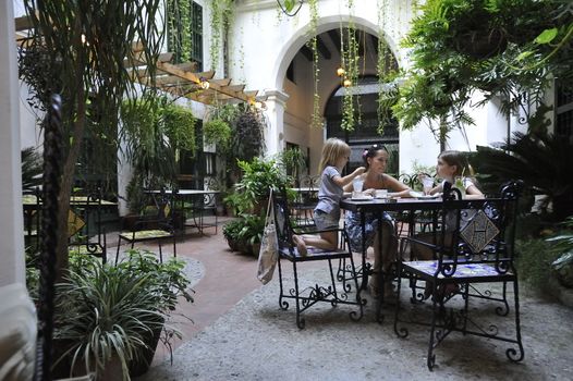 Family is having dinner in the old colonial  patio.