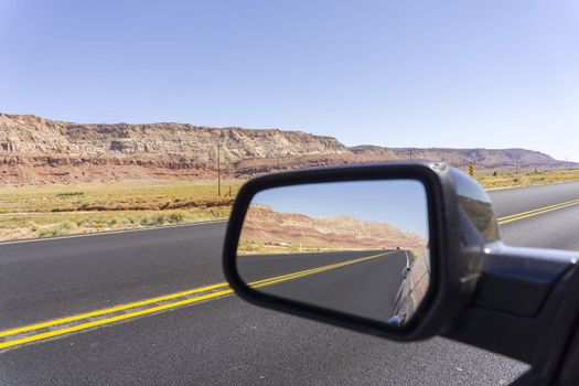 Road and landscape in rear vision mirror through  Arizona.
