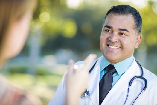 Hispanic Male Doctor or Nurse Talking With a Patient Outdoors.