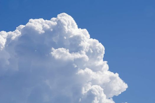 Big white cumulus cloud against blue sky