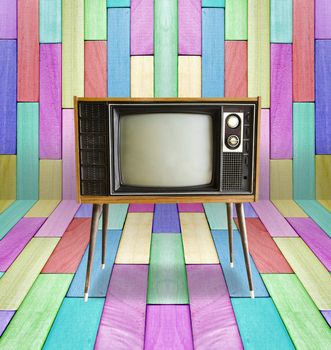 Old vintage TV television on colorful wooden wall background.