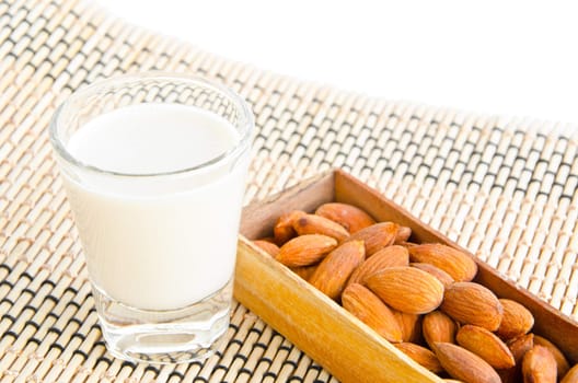 almonds drink with almonds on wooden mat.