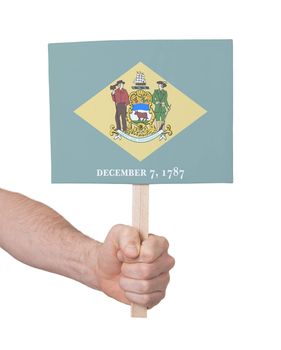 Hand holding small card, isolated on white - Flag of Delaware