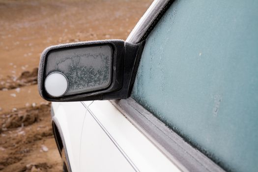 View of the side mirror on a frozen over car