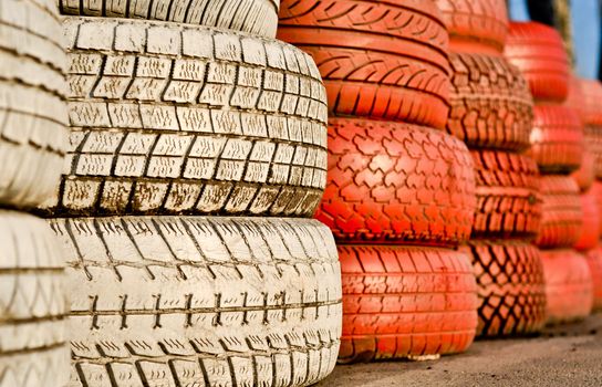 close up of racetrack fence of white and red of old tires