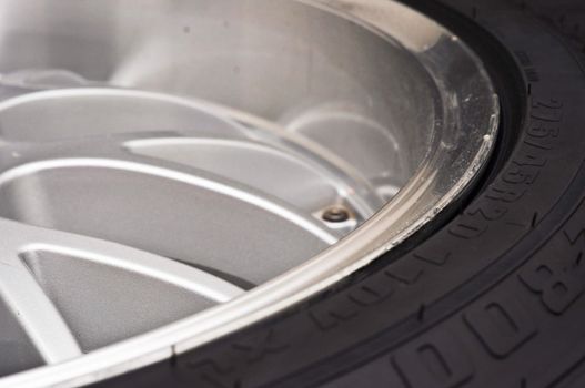 low-profile car wheel on a black background close up