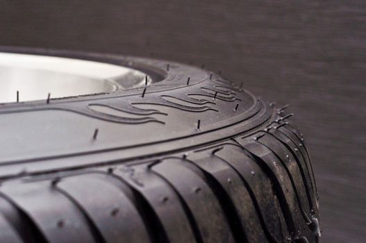 low-profile car wheel on a black background close up