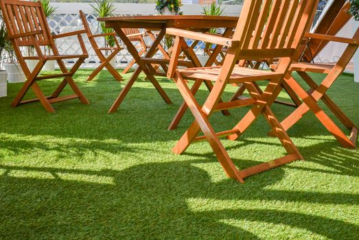 wooden chairs and table on the green grass